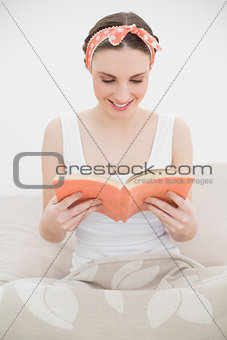 Smiling young woman reading a book