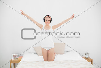 Young woman raising her arms while listening to music
