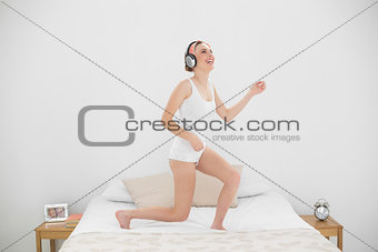 Laughing woman playing air guitar while listening to music