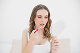 Young woman using lip gloss