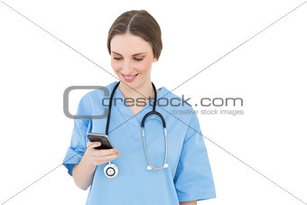 Young woman doctor looking at her smartphone