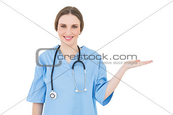 Smiling young woman doctor presenting with her hand