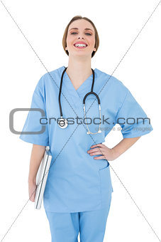 Young female doctor holding a notebook and laughing into the camera