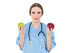Pretty woman doctor holding two apples