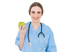 Young woman doctor holding a green apple