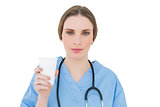 Female doctor holding a plastic cup and looking into the camera