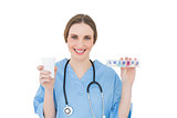Young female doctor holding a plastic cup and medicine