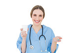 Female doctor holding a plastic cup and blue pills