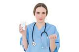 Young female doctor holding a plastic cup and presenting with her hand