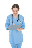 Smiling female doctor working with her clipboard