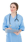 Thoughtful female doctor holding a clipboard