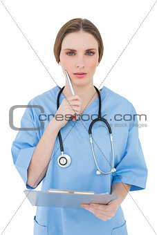 Thoughtful woman doctor keeping her clipboard