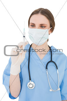 Pretty young woman doctor holding an injection