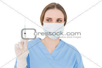 Young brunette physician holding a syringe