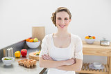 Beautiful young woman posing in her kitchen with arms crossed