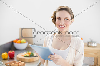 Young gorgeous woman using her tablet smiling at camera
