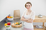 Brunette woman posing in kitchen with arms crossed in her kitchen