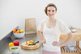 Attractive woman posing in her kitchen with hands on hips