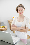 Content calm woman posing in her kitchen with arms crossed