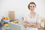 Young beautiful woman posing in he kitchen with arms crossed
