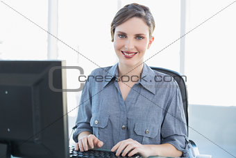 Content businesswoman working on computer at her desk