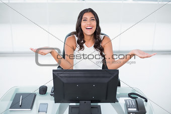 Laughing cute businesswoman sitting behind desk
