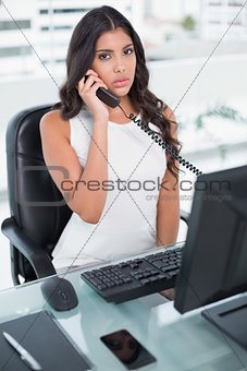 Serious cute businesswoman phoning