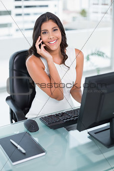 Cheerful cute businesswoman phoning on smartphone