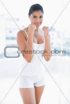 Smiling toned brunette standing with lifted fists