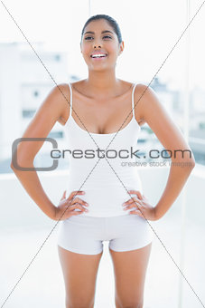 Laughing toned brunette standing hands on hips