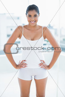 Smiling toned brunette standing hands on hips