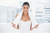 Smiling toned brunette holding towel