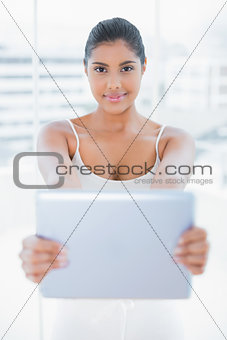 Smiling toned brunette holding tablet