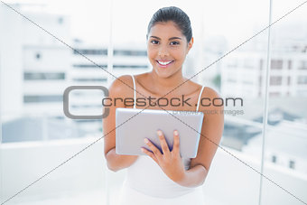 Cheerful toned brunette holding tablet