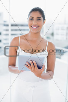 Laughing toned brunette using tablet