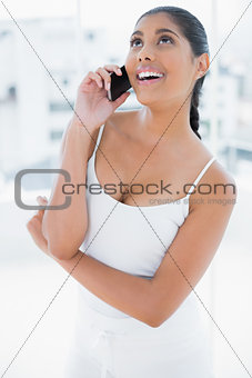 Laughing toned brunette phoning with mobile phone