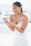 Laughing toned brunette holding mobile phone