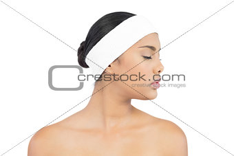 Calm nude brunette with hairband closing her eyes