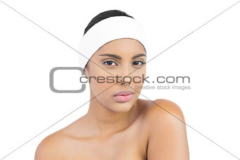 Calm nude brunette with hairband looking at camera