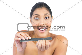 Cheerful nude brunette using nail file