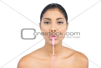 Frowning nude brunette holding toothbrush
