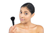 Content nude brunette holding powder brush