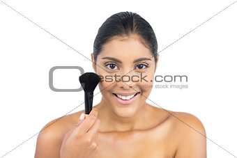 Smiling nude brunette holding powder brush