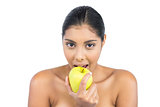 Happy nude brunette eating green apple