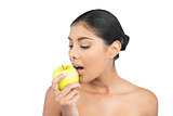 Calm nude brunette eating green apple