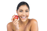 Cheerful nude brunette holding red apple