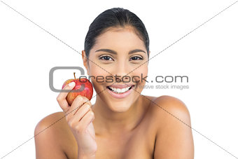 Cheerful nude brunette holding red apple