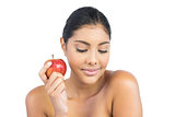 Peaceful nude brunette holding red apple