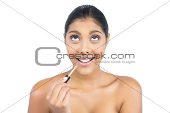 Excited nude brunette holding lip gloss