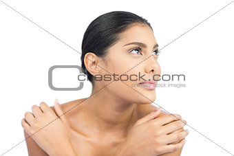Content nude brunette holding shoulders looking up